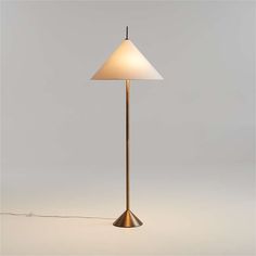 a floor lamp with a white shade on the base and a light bulb attached to it