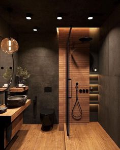 a modern bathroom with wooden floors and black walls, along with an open shower stall