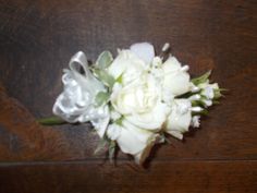 a bouquet of white flowers sitting on top of a wooden table