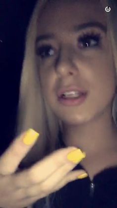 a woman with long blonde hair and yellow nails