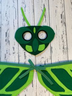 a paper cut out of a green insect with two eyes on it's face