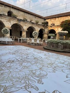 an outdoor wedding venue with tables and chairs set up in the courtyard for guests to sit down