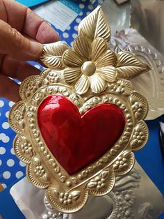 a red heart is placed in a gold frame