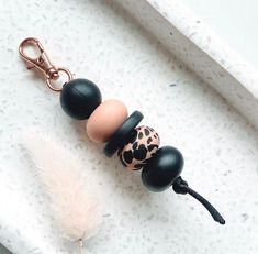 three beads with black and white designs on them are hanging from a keychain