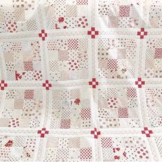 a white and red quilt with squares on it