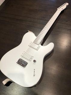 an electric guitar sitting on top of a wooden floor