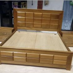 a wooden bed frame with drawers and headboard in a store display room or office