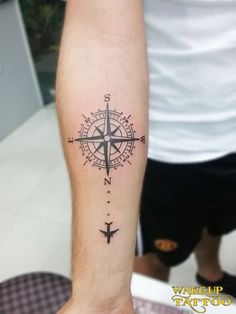 a man with a compass tattoo on his arm