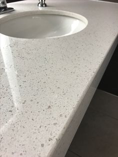 a white counter top with a sink and faucet in the corner next to it