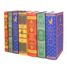 four books are lined up in different colors and designs, one is blue, the other is red