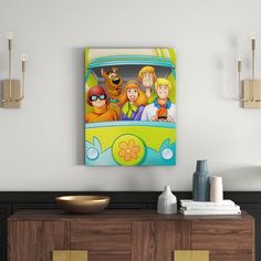 the scooby gang is hanging on the wall above a dresser in this modern living room