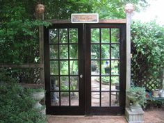 an open door leading into a lush green garden