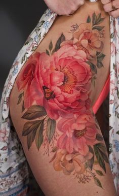 a woman's thigh with flowers on it and a butterfly sitting on the flower