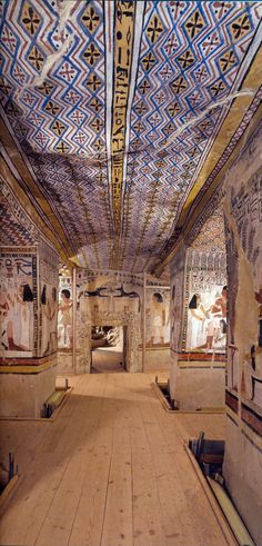 an egyptian style room with painted ceilings and wooden floors