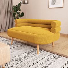 a yellow couch sitting on top of a wooden floor next to a white and black rug