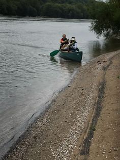 two people in a canoe paddling down the river