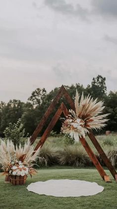 an outdoor ceremony setup with tall grass and flowers