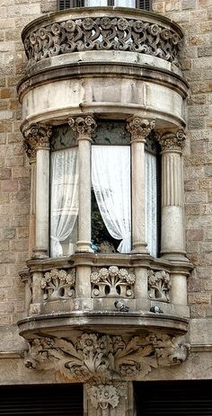 an old building has a window with curtains on it