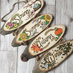 three wooden signs that say spring, summer, and autumn on wood planks with flowers