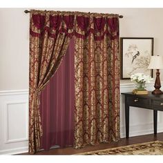 a living room scene with focus on the drapes and window curtains, which are decorated in red and gold