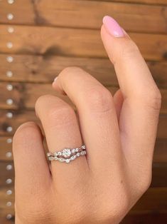 a woman's hand with a pink manicured nail and ring on her finger