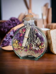 a bottle filled with lots of different types of flowers sitting on top of a wooden table