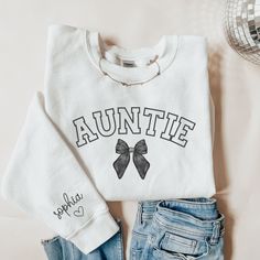 This custom aunt sweatshirt is a great gift for an aunt or new aunt to be! This sweatshirt can be given as a gift to a friend or loved one. This sweatshirt is made with the highest quality materials and is super comfy, soft and cozy!! Please enter the name(s) of child(ren) you would on the sleeve in the personalized section. ABOUT THIS ITEM: - Gildan Sweatshirt - Long Sleeve Crew Neck - Ribbed Neck Collar - Double-Needle Stitching - Not Vinyl Printing - Shirt is direct to fabric print (DTF) - Ma Auntie And Nephew Shirts, Auntie Era Sweatshirt, Aunt Sweatshirt Ideas, Auntie Shirt Ideas, Relaxed Fit Name Print Sweatshirt Gift, Personalized Fall Sweatshirt For Gift, Customizable Relaxed Fit Sweatshirt For Gift, Customizable Relaxed Fit Sweatshirt As A Gift, Auntie Outfits