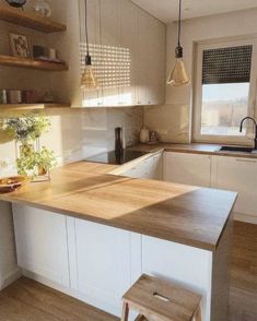 a kitchen with an island and wooden counter tops in the center, along with two stools