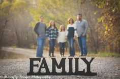 a family standing in the middle of a road with their name cut out on it