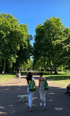 two women walking with their dog in the park