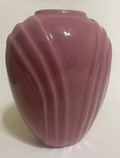 a pink vase sitting on top of a white table