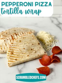 two pita breads on a white marble counter top with red peppers and shredded cheese