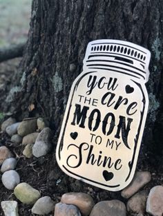 a mason jar that says you are the moon to my shine next to a tree