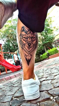 a man's leg with a geometrical tattoo on it and his shoes in the foreground