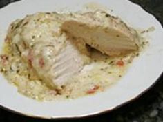 a white plate topped with meat and gravy on top of a black table