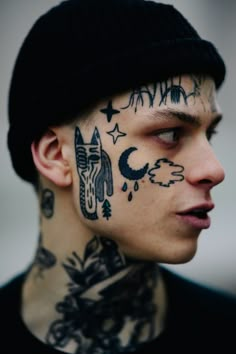 a man with tattoos on his face and neck