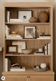 a wooden book shelf with books and other items on it