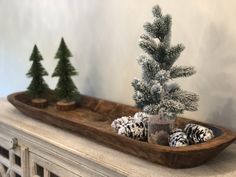 a wooden tray with pine cones and trees in it