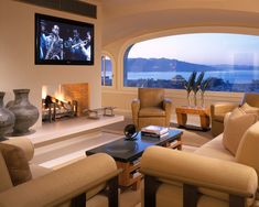 a living room filled with furniture and a flat screen tv mounted to the wall over a fireplace