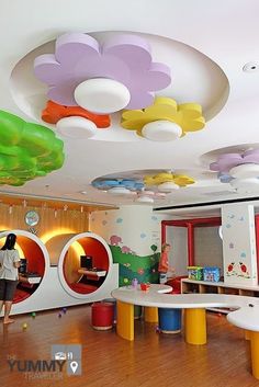 the children's playroom is decorated in bright colors and features round tables, colorful stools, and circular mirrors