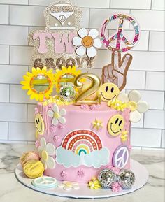 a pink cake with sunflowers and other decorations