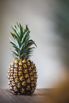 a pineapple sitting on top of a wooden table