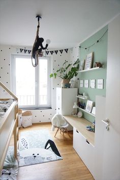 a child's bedroom with green walls and white furniture