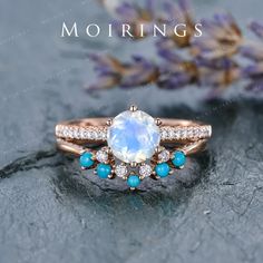 an image of a ring with blue stones and diamonds on it, sitting next to lavender flowers