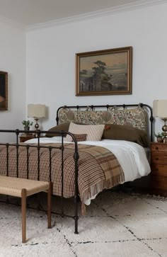 a bed sitting in a bedroom next to a painting on the wall and a wooden dresser