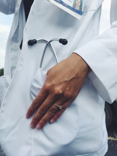 a person with a stethoscope on their left hand is wearing a white coat