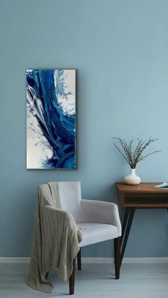 a blue and white painting on the wall next to a chair