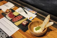 a wooden bowl filled with different types of food on top of a table next to papers