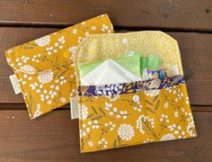 two yellow and white fabric bags sitting on top of a wooden table next to each other