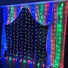 a room with lights on the walls and curtains around it, all lit up in different colors